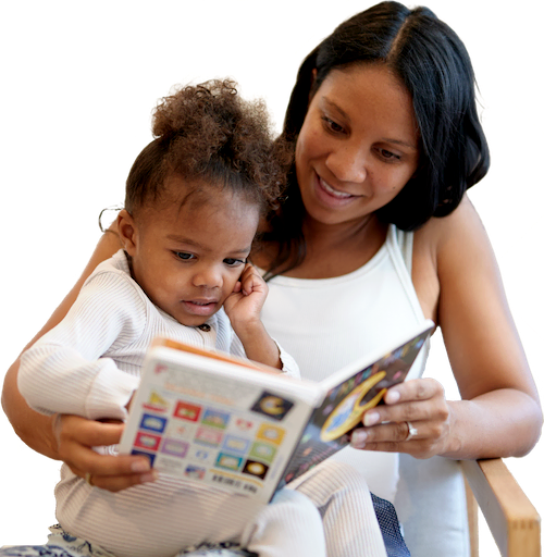 African American mother reading a bedtime story to her daughter seated in her lap